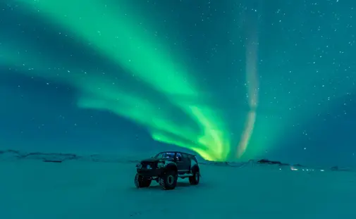 Private superjeep under the northern lights in winter on a private tour.