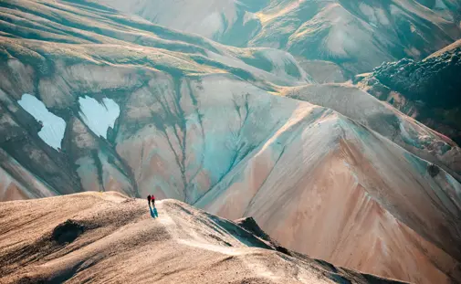 Aerial mountain view of two people enjoying views over a walley on a private superjeep tour.