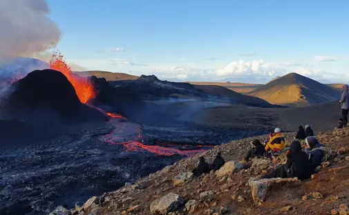 Private Reykjanes Peninsula travelers viewing an active erupting volcano.